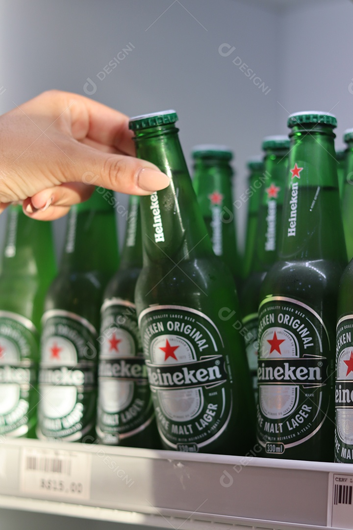 Linda mão de mulher retirando bebida alcoólica de câmara fria