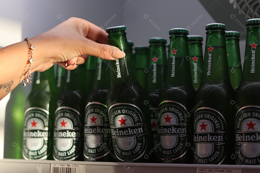 Linda mão de mulher retirando bebida alcoólica de câmara fria