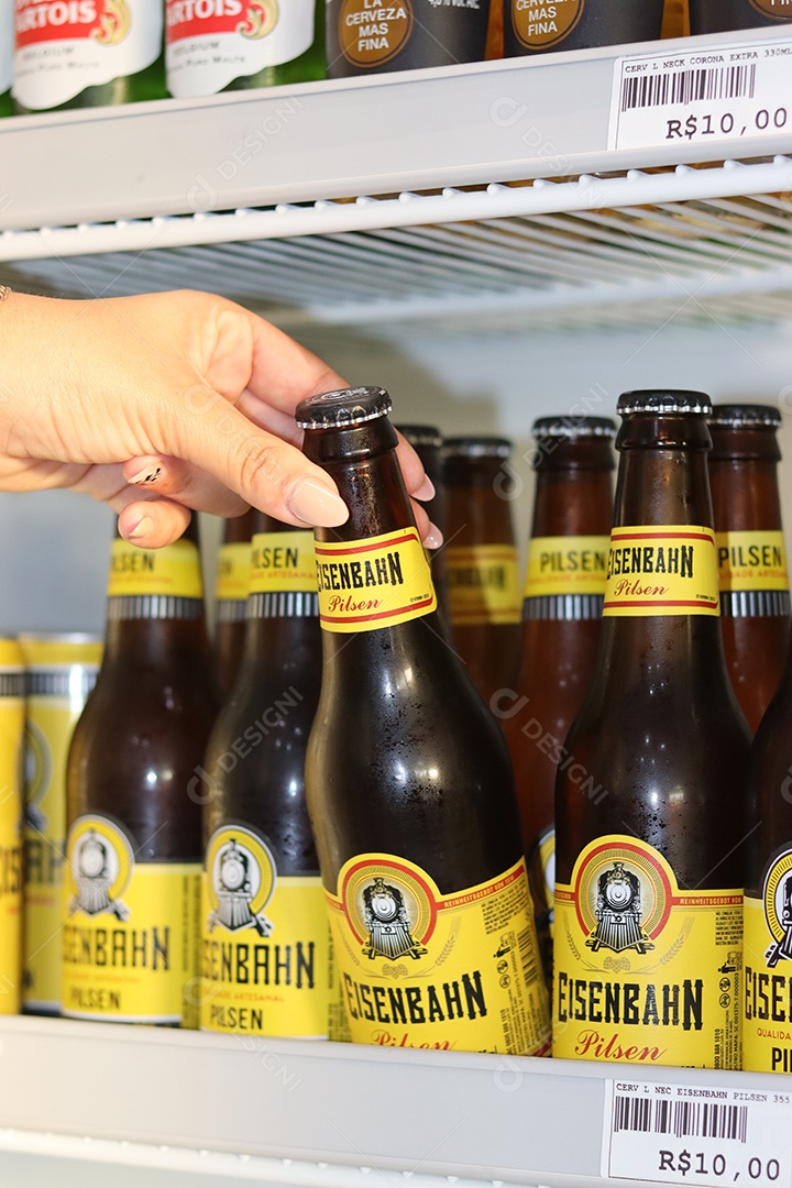 Linda mão de mulher retirando bebida alcoólica de câmara fria