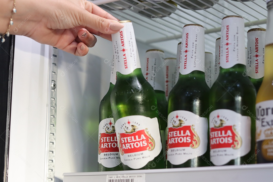 Linda mão de mulher retirando bebida alcoólica de câmara fria