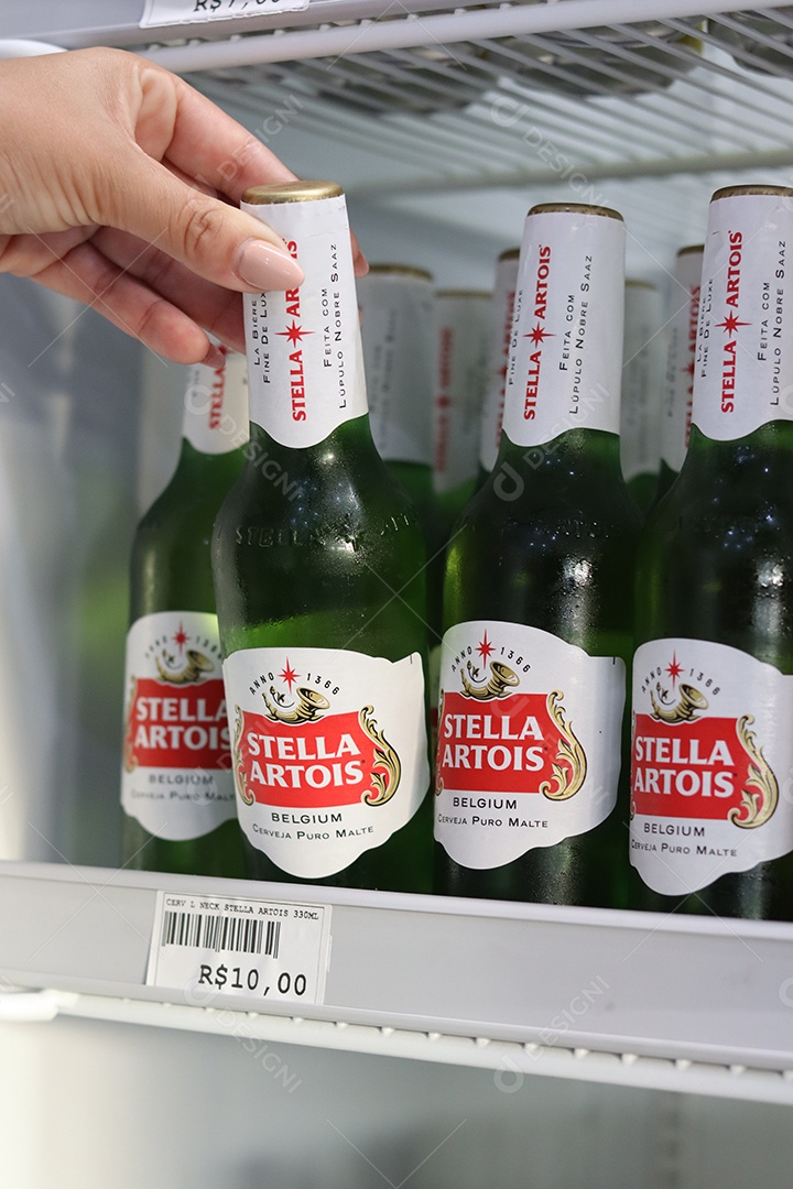 Linda mão de mulher retirando bebida alcoólica de câmara fria