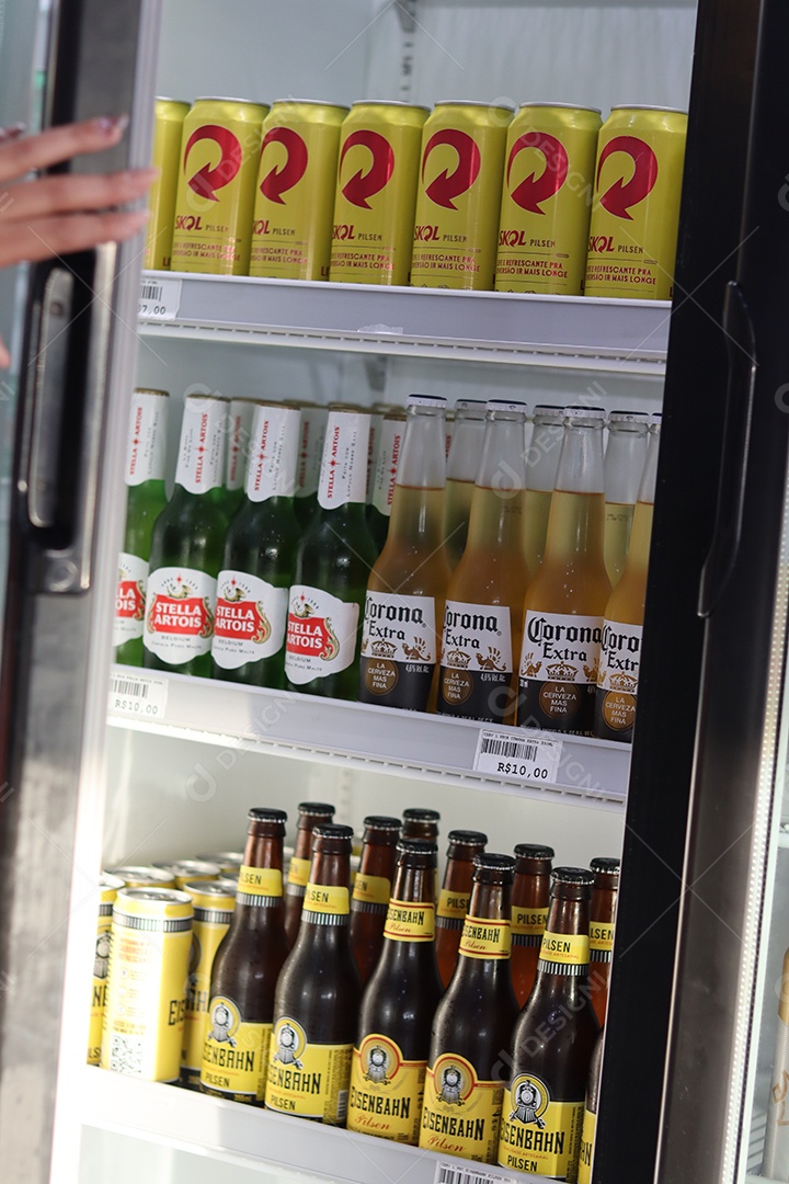 Linda mão de mulher abrindo câmara fria com bebidas alcoólicas