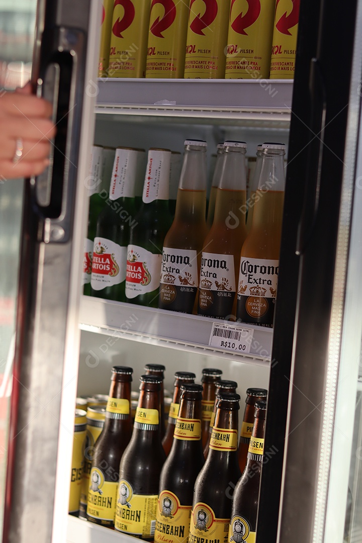 Linda mão de mulher abrindo câmara fria com bebidas alcoólicas