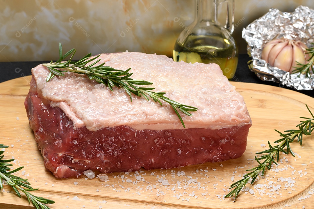 Carne bovina alho e alecrim sobre a tábua de madeira