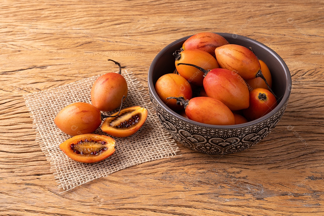 Tamarillos ou tomates de árvore dentro de vasilha sobre fundo de madeira