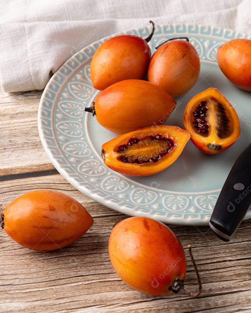 Tamarillos ou tomates de árvore encima de prato sobre fundo de madeira