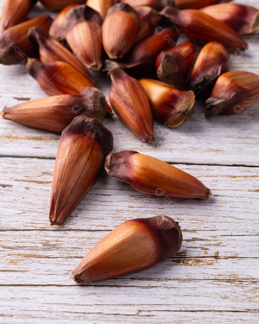 Pinhões ou sementes de pinheiro sobre mesa de madeira