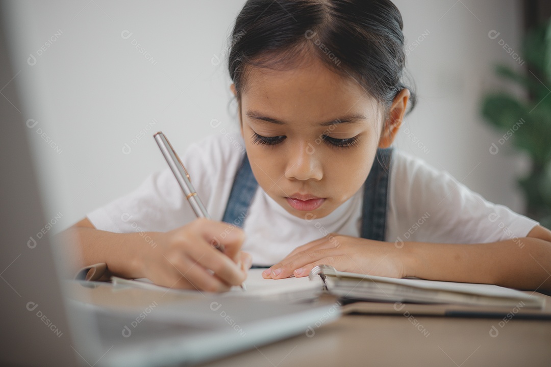 Garotinha linda e estudiosa concentrada na sua tarefa