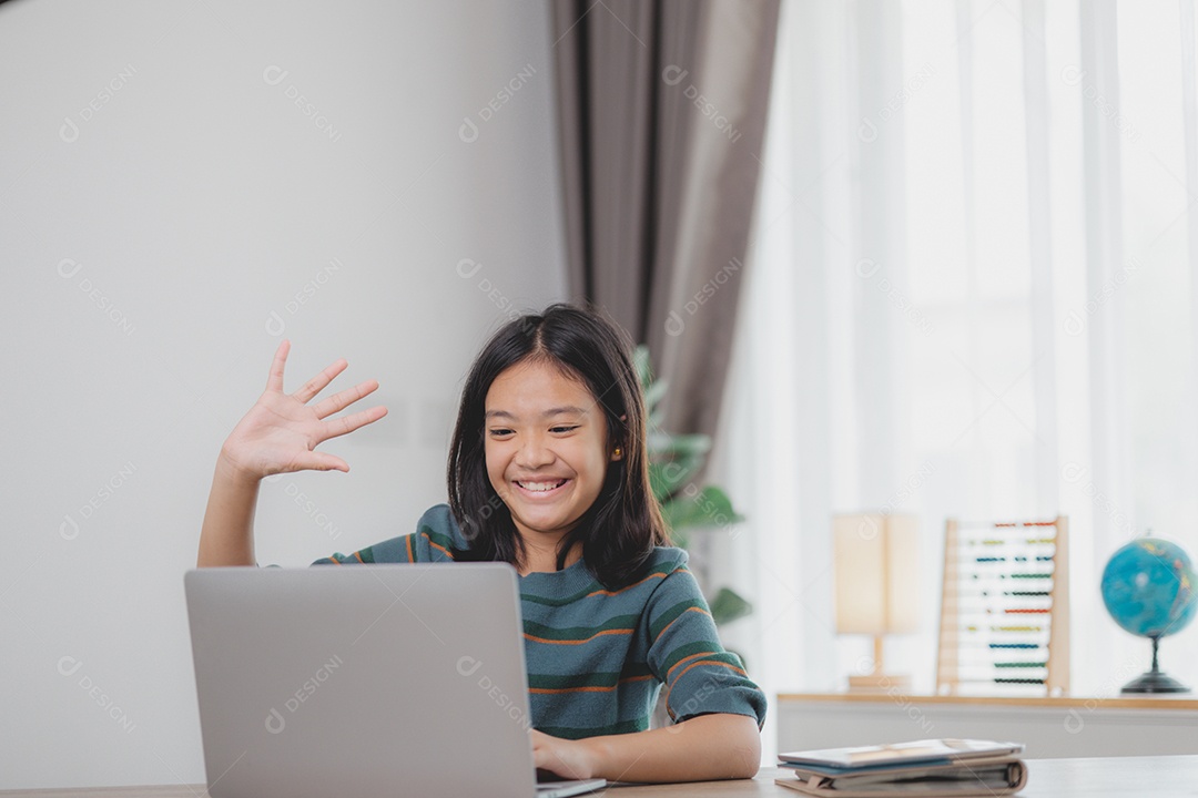 Garota sorrindo com mão pra cima possivelmente por causa de algo que viu no notebook