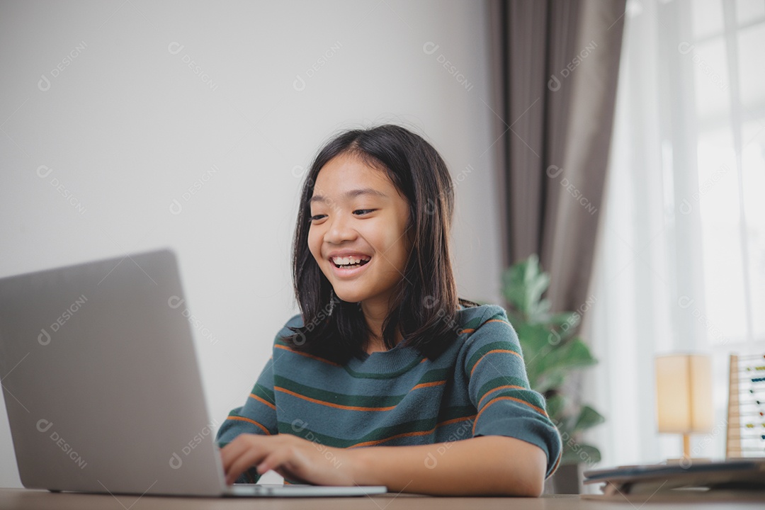 Garota rindo e fazendo careta possivelmente por causa de algo que viu no notebook