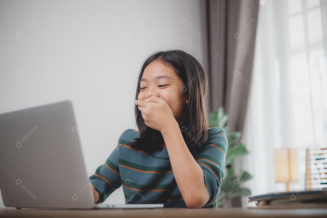 Garota rindo e fazendo careta possivelmente por causa de algo que viu no notebook