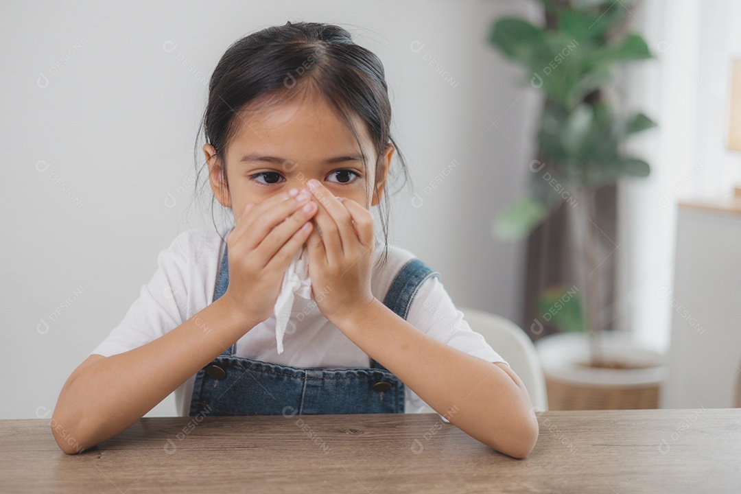 Uma criança resfriada com lenço no nariz