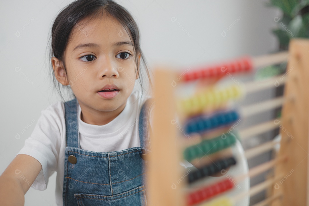 Linda menina aprendendo a contar usando ábaco na sala de aula