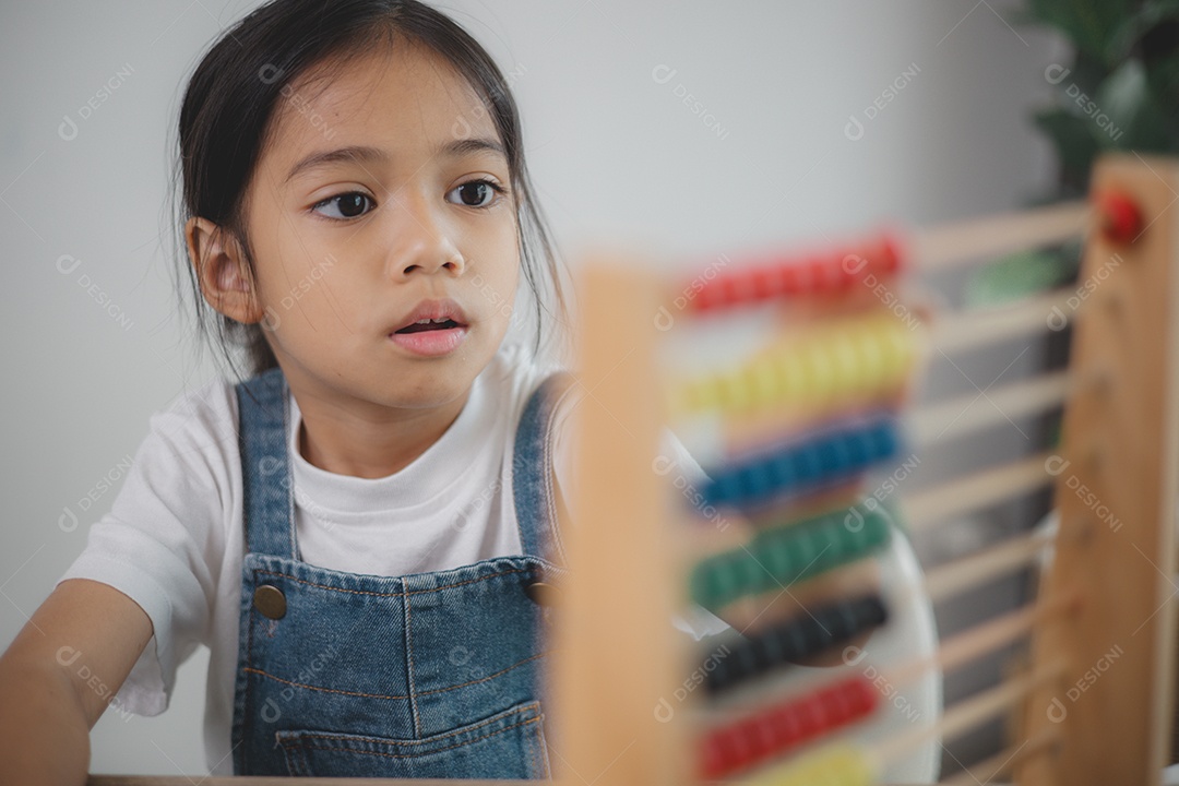 Linda menina aprendendo a contar usando ábaco na sala de aula