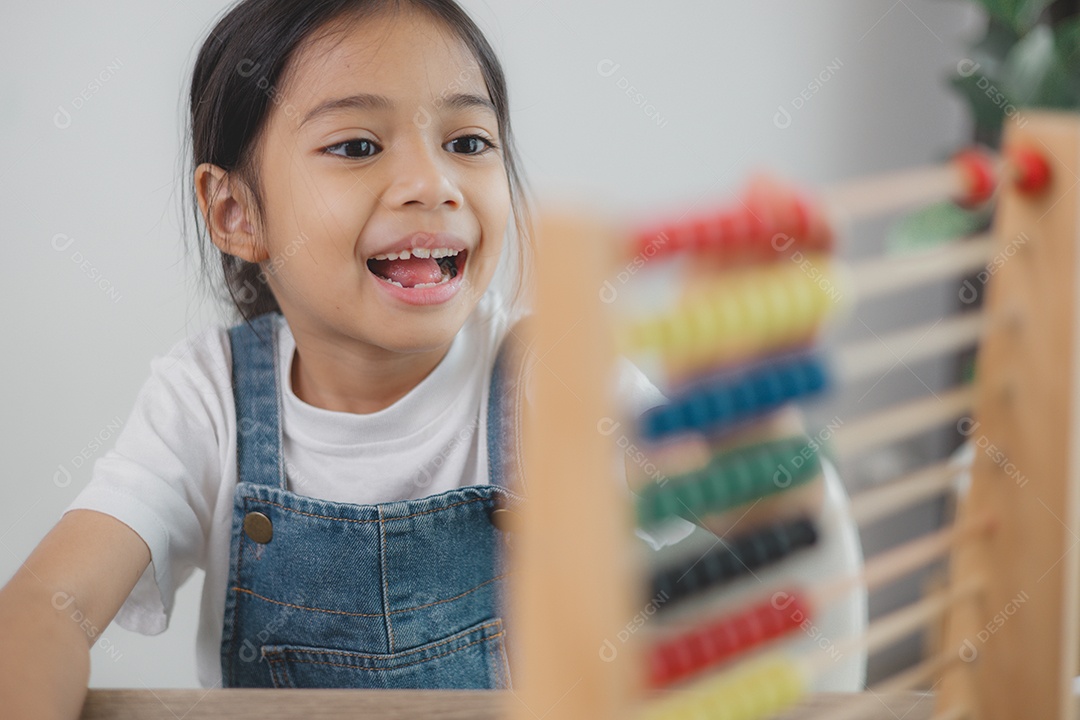 Linda menina asiática aprendendo a contar usando um ábaco na sala de aula