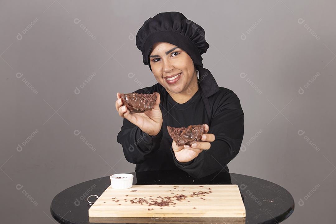 Mulher linda jovem chefe de cozinha comendo ovos de páscoa