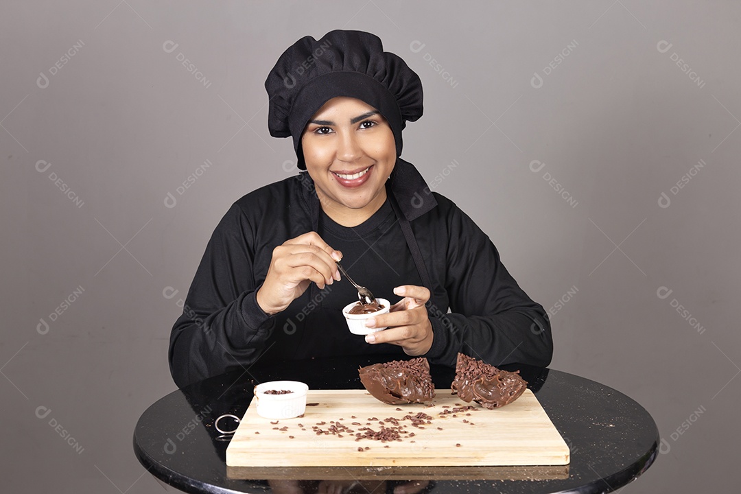 Mulher linda jovem chefe de cozinha comendo ovos de páscoa