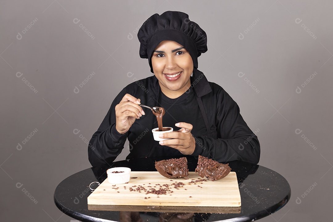 Mulher linda jovem chefe de cozinha comendo ovos de páscoa