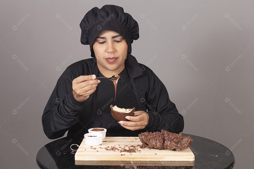 Mulher linda jovem chefe de cozinha comendo ovos de páscoa