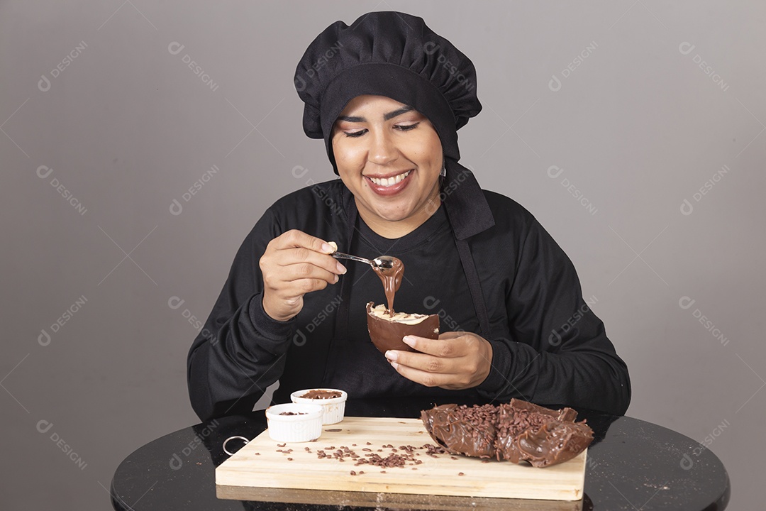 Mulher linda jovem chefe de cozinha comendo ovos de páscoa