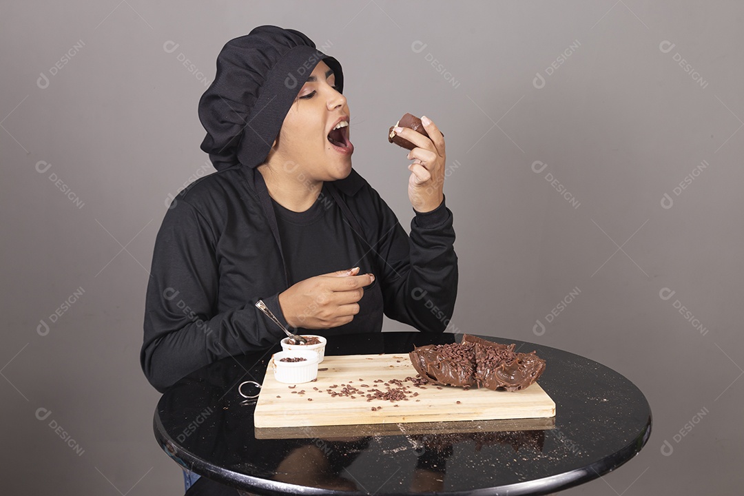 Mulher linda jovem chefe de cozinha comendo ovos de páscoa