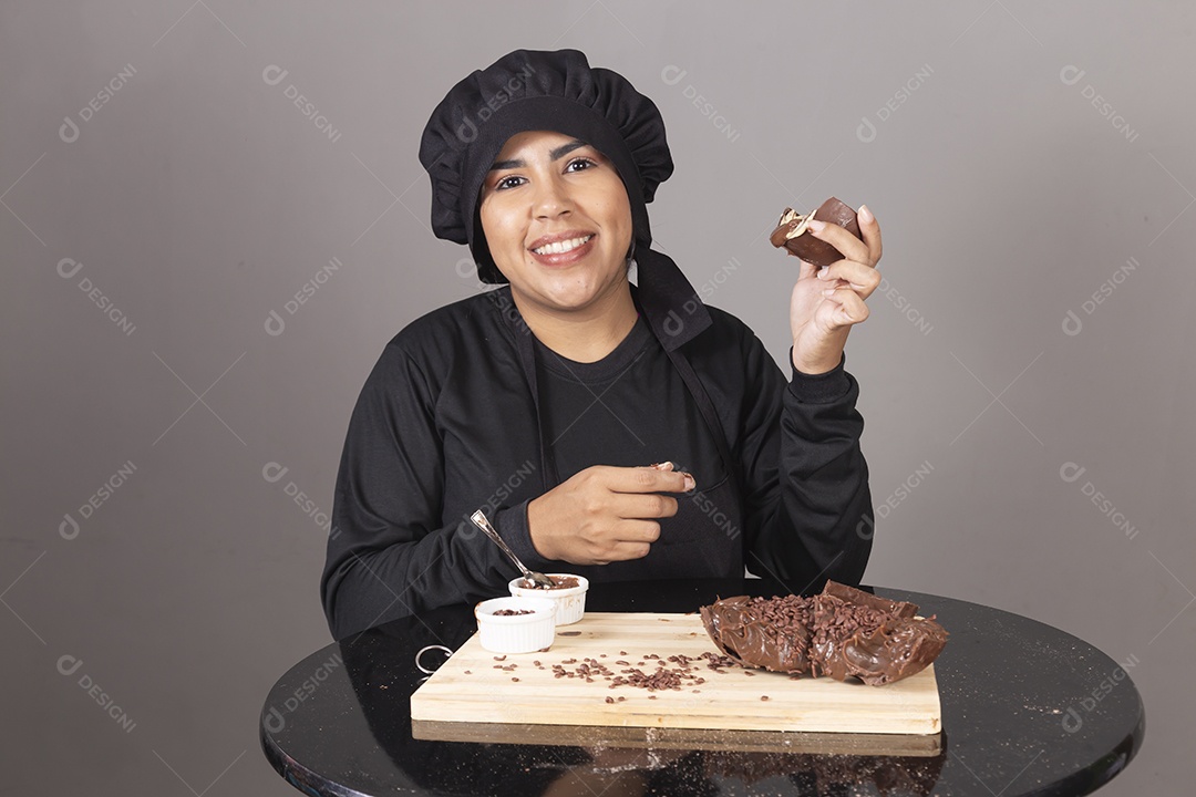 Mulher linda jovem chefe de cozinha comendo ovos de páscoa