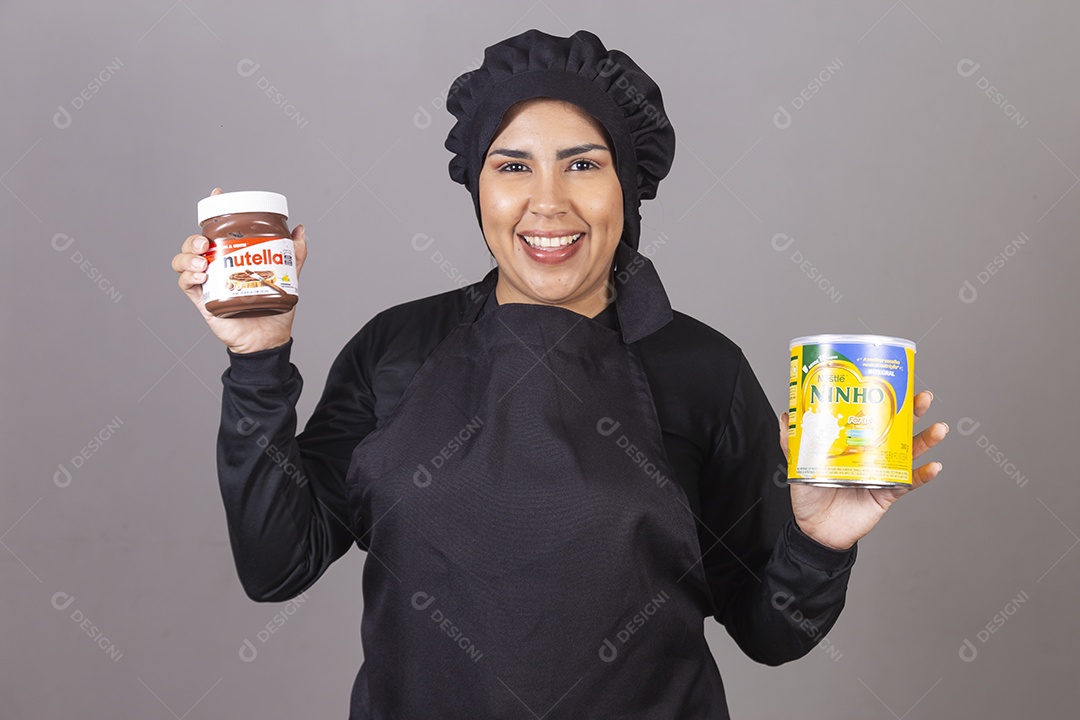 Mulher linda jovem chefe de cozinha segurando pote leite ninho e nutella