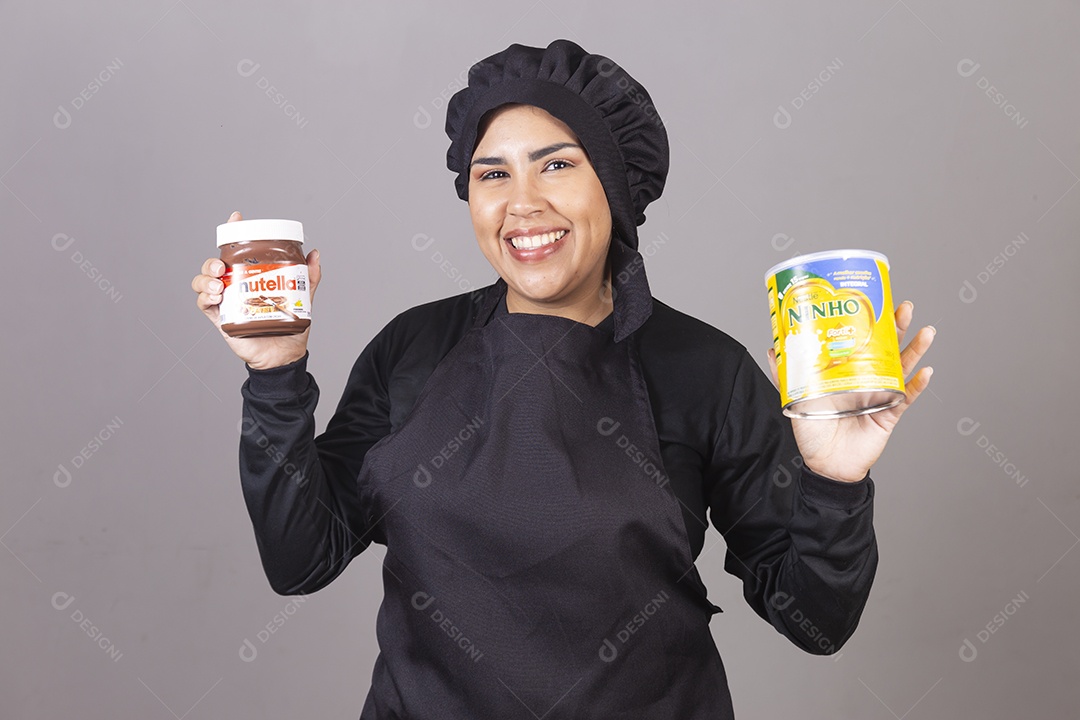Mulher linda jovem chefe de cozinha segurando pote leite ninho e nutella