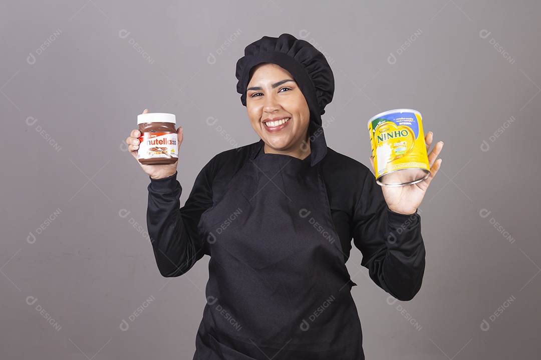Mulher linda jovem chefe de cozinha segurando pote leite ninho e nutella
