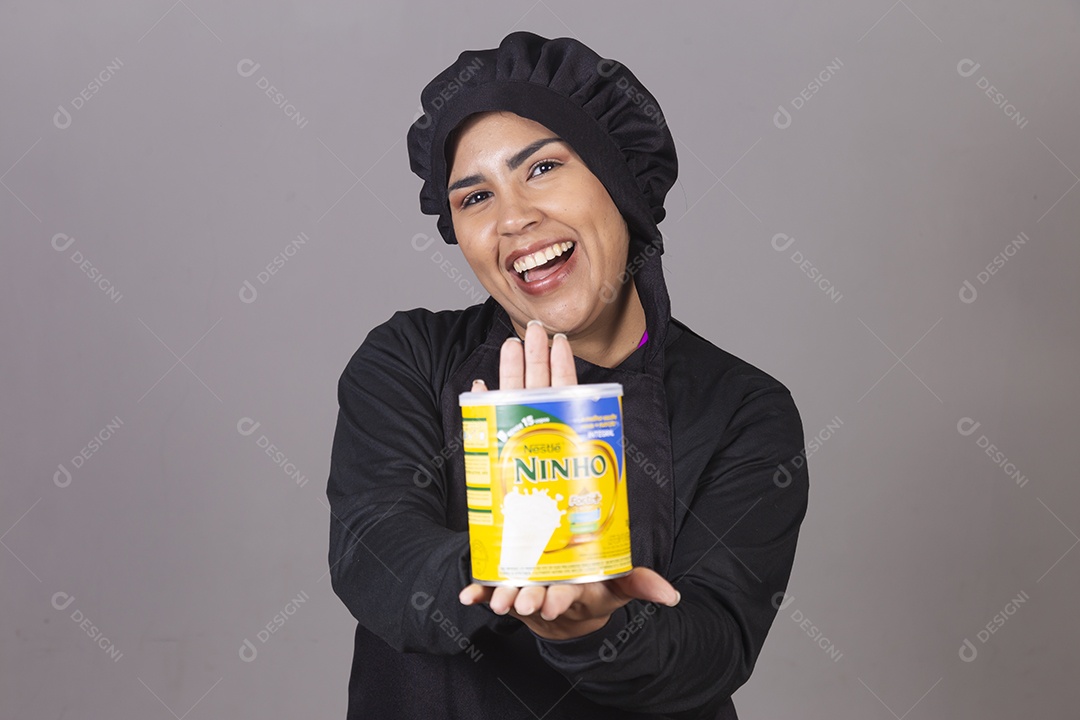 Mulher linda jovem chefe de cozinha segurando pote leite ninho