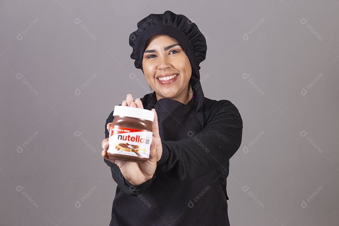Mulher linda jovem chefe de cozinha segurando pote de nutella