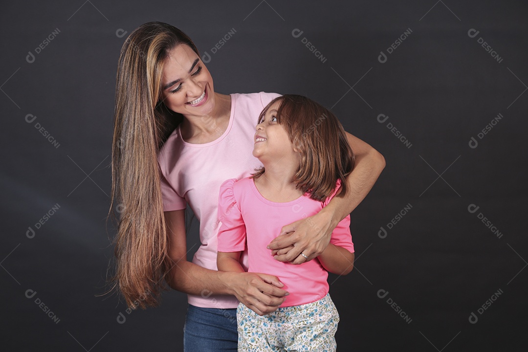 Mãe e filha felizes sorridentes sobre fundo isolado