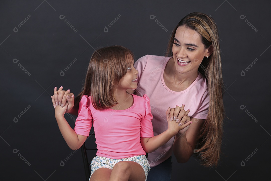 Mãe e filha felizes sorridentes sobre fundo isolado
