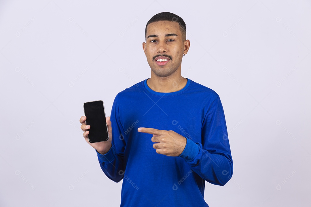 Homem jovem sorridente usando camiseta azul segurando celular smartphone