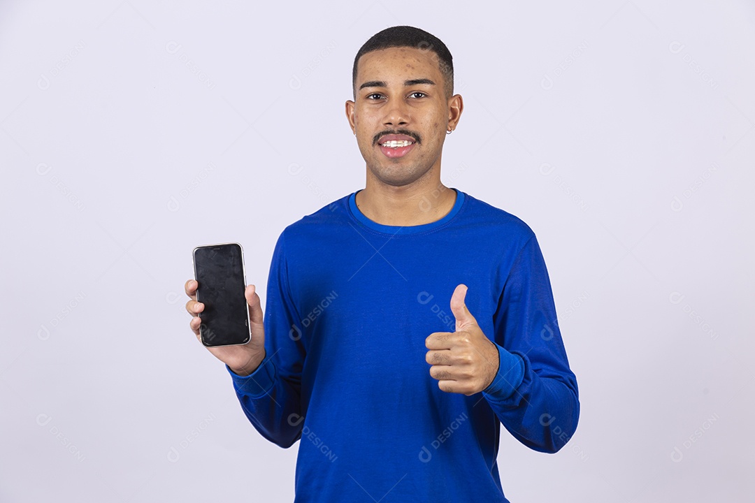Homem jovem sorridente usando camiseta azul segurando celular smartphone