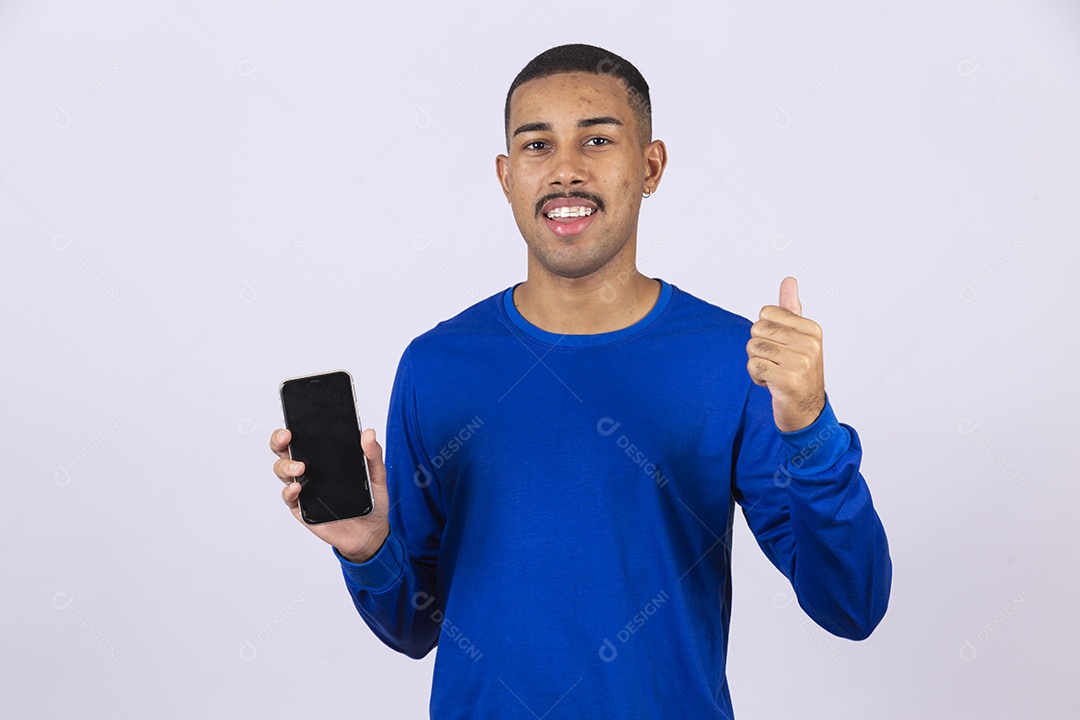 Homem jovem sorridente usando camiseta azul segurando celular smartphone