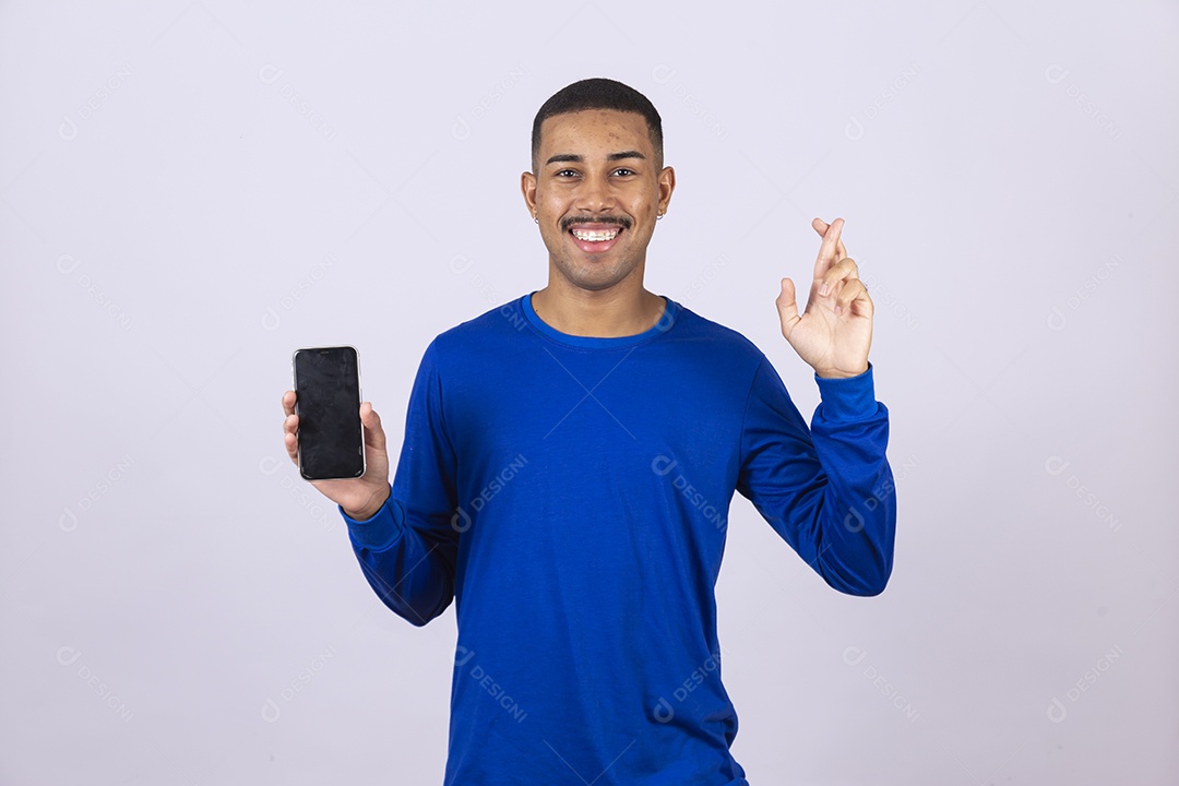 Homem jovem sorridente usando camiseta azul segurando celular smartphone