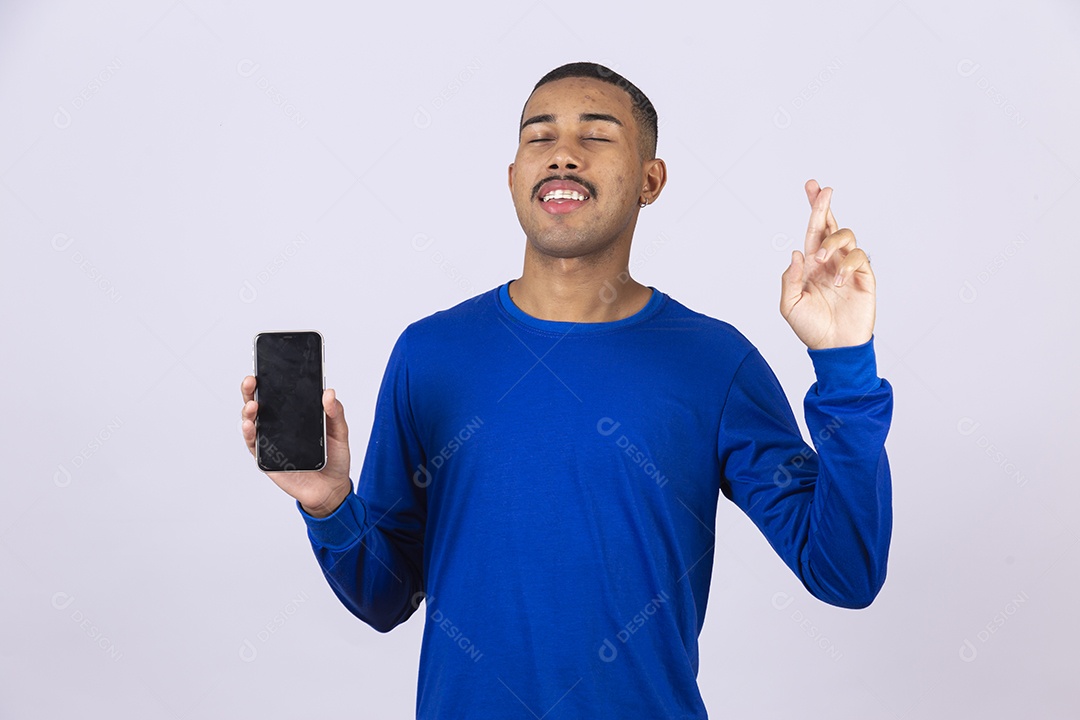 Homem jovem sorridente usando camiseta azul segurando celular smartphone