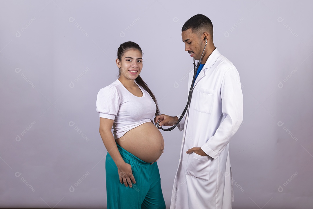 Homem jovem médico ao lado de mulher gravída sobre fundo isolado