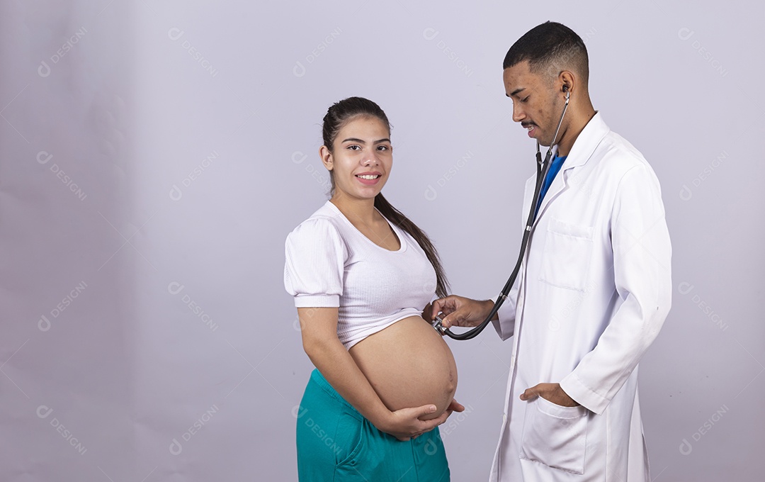 Homem jovem médico ao lado de mulher gravída sobre fundo isolado