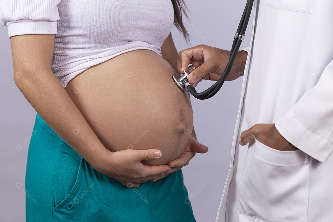 Homem jovem médico ao lado de mulher gravída sobre fundo isolado