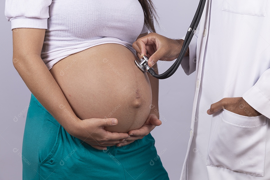 Homem jovem médico ao lado de mulher gravída sobre fundo isolado