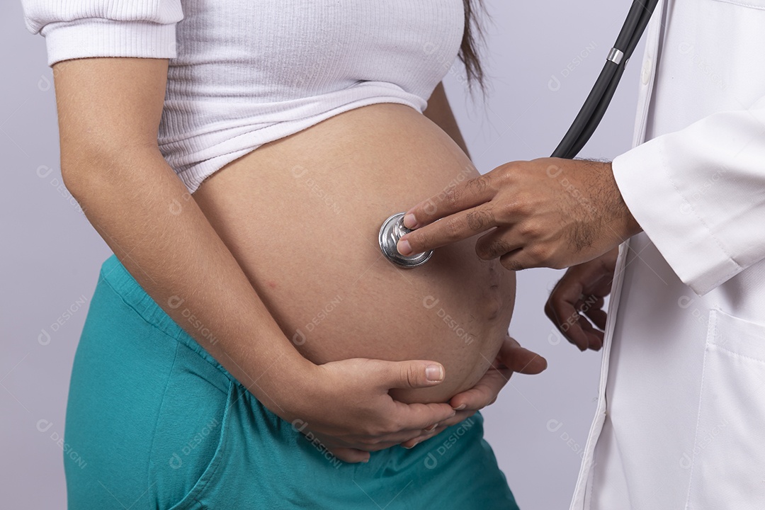 Homem jovem médico ao lado de mulher gravída sobre fundo isolado