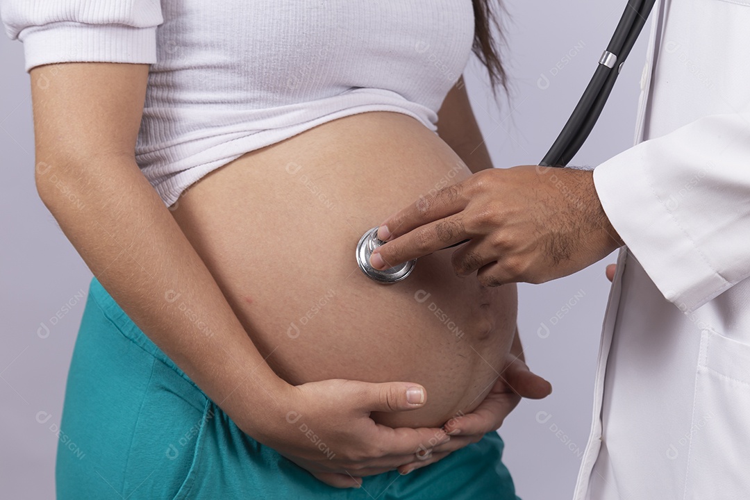 Homem jovem médico ao lado de mulher gravída sobre fundo isolado