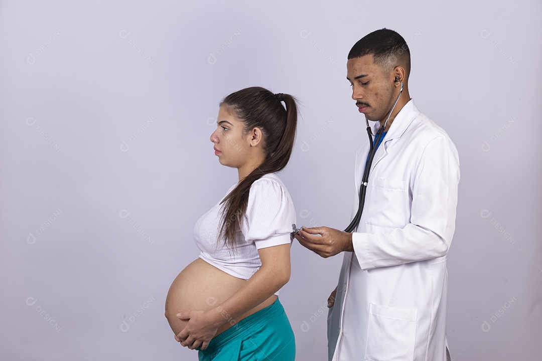 Homem jovem médico ao lado de mulher gravída sobre fundo isolado