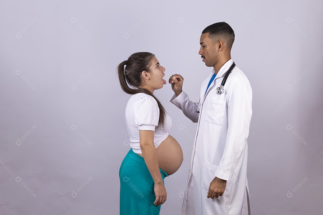 Homem jovem médico ao lado de mulher gravída sobre fundo isolado