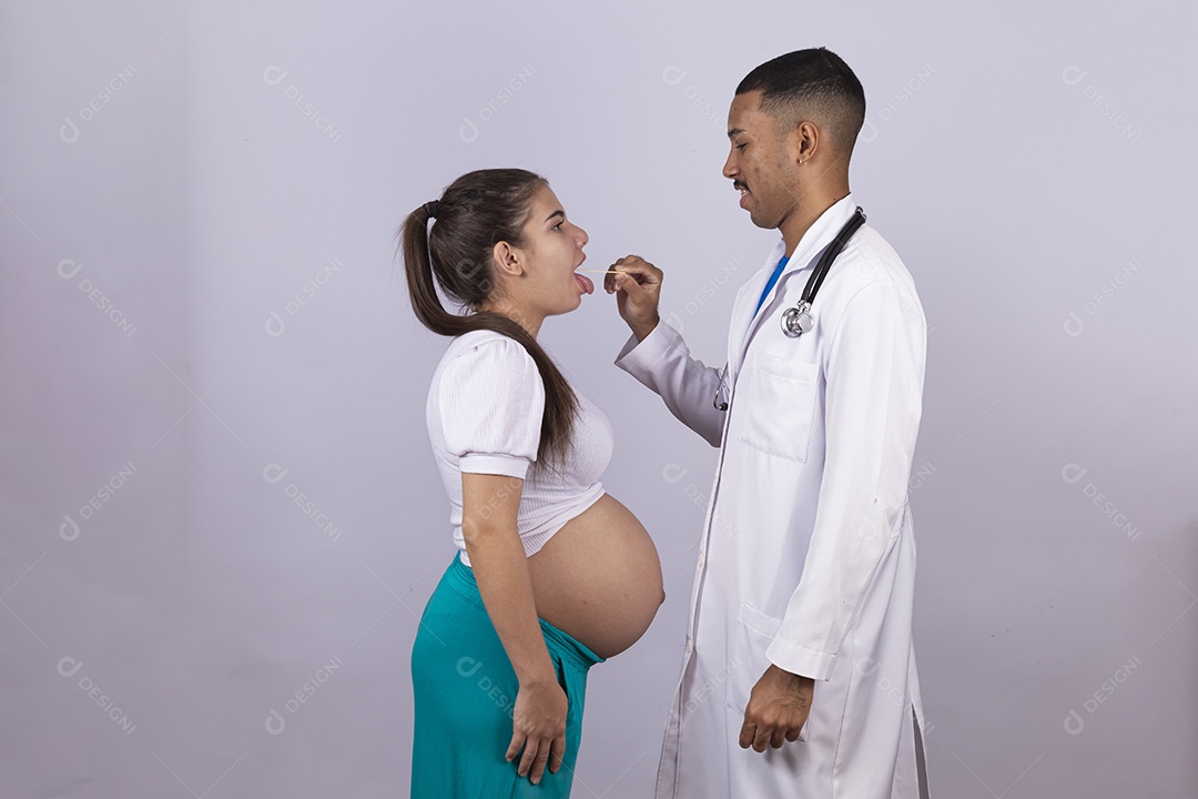 Homem jovem médico ao lado de mulher gravída sobre fundo isolado