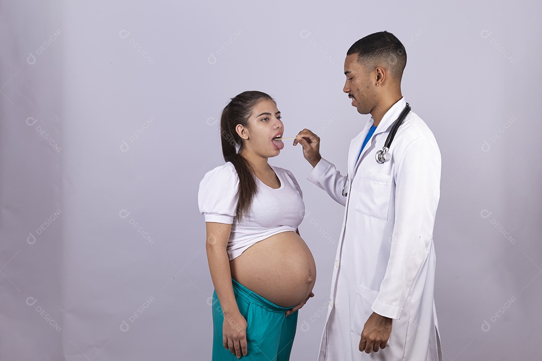 Homem jovem médico ao lado de mulher gravída sobre fundo isolado