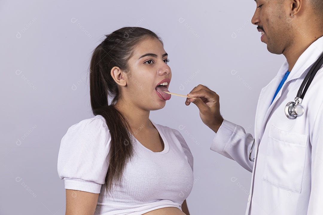 Homem jovem médico ao lado de mulher gravída sobre fundo isolado