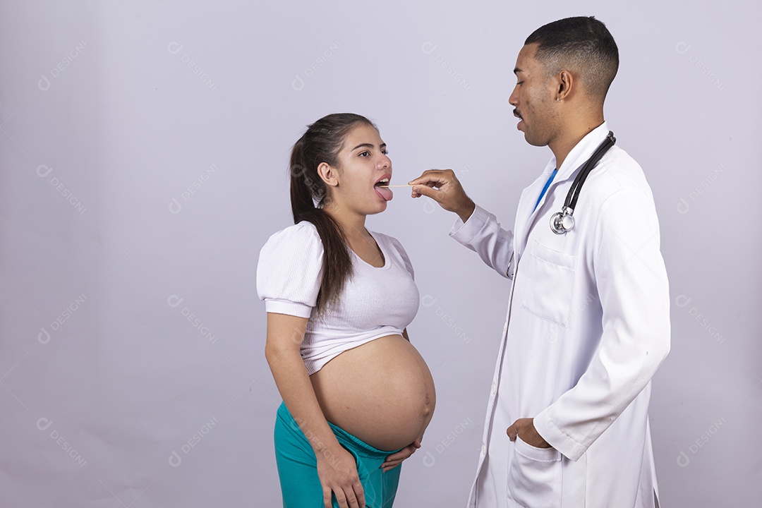 Homem jovem médico ao lado de mulher gravída sobre fundo isolado